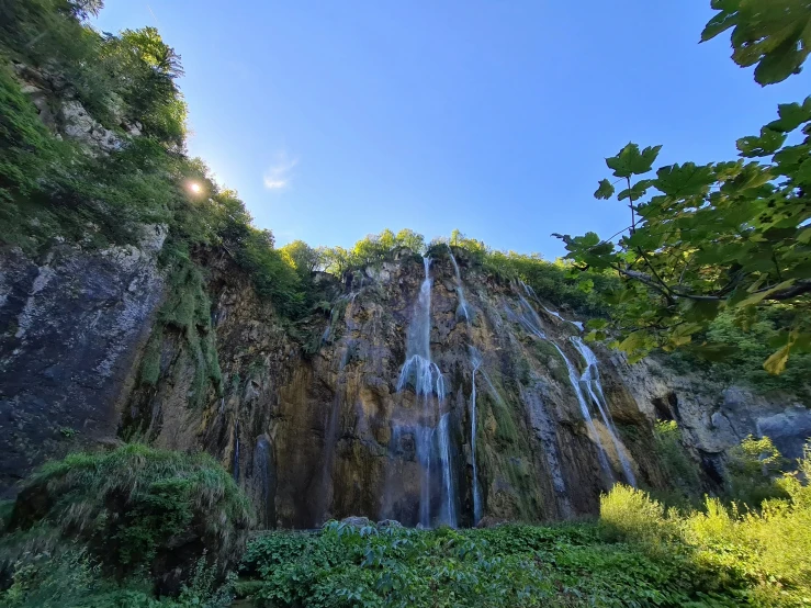 a large waterfall surrounded by green trees and bushes