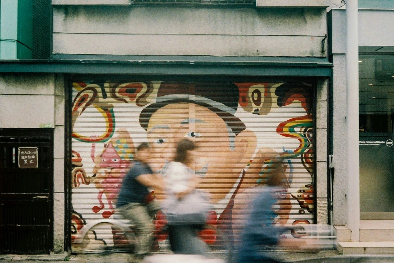 two men walk past an older, graffiti covered wall