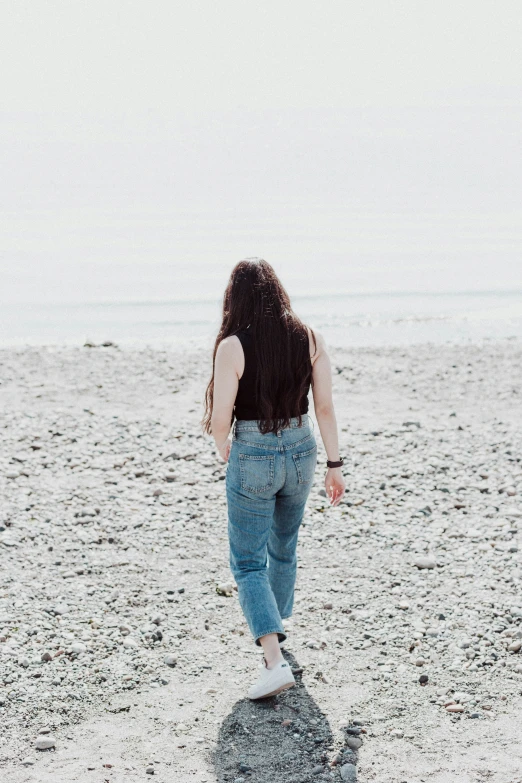 a woman is standing in the sand alone