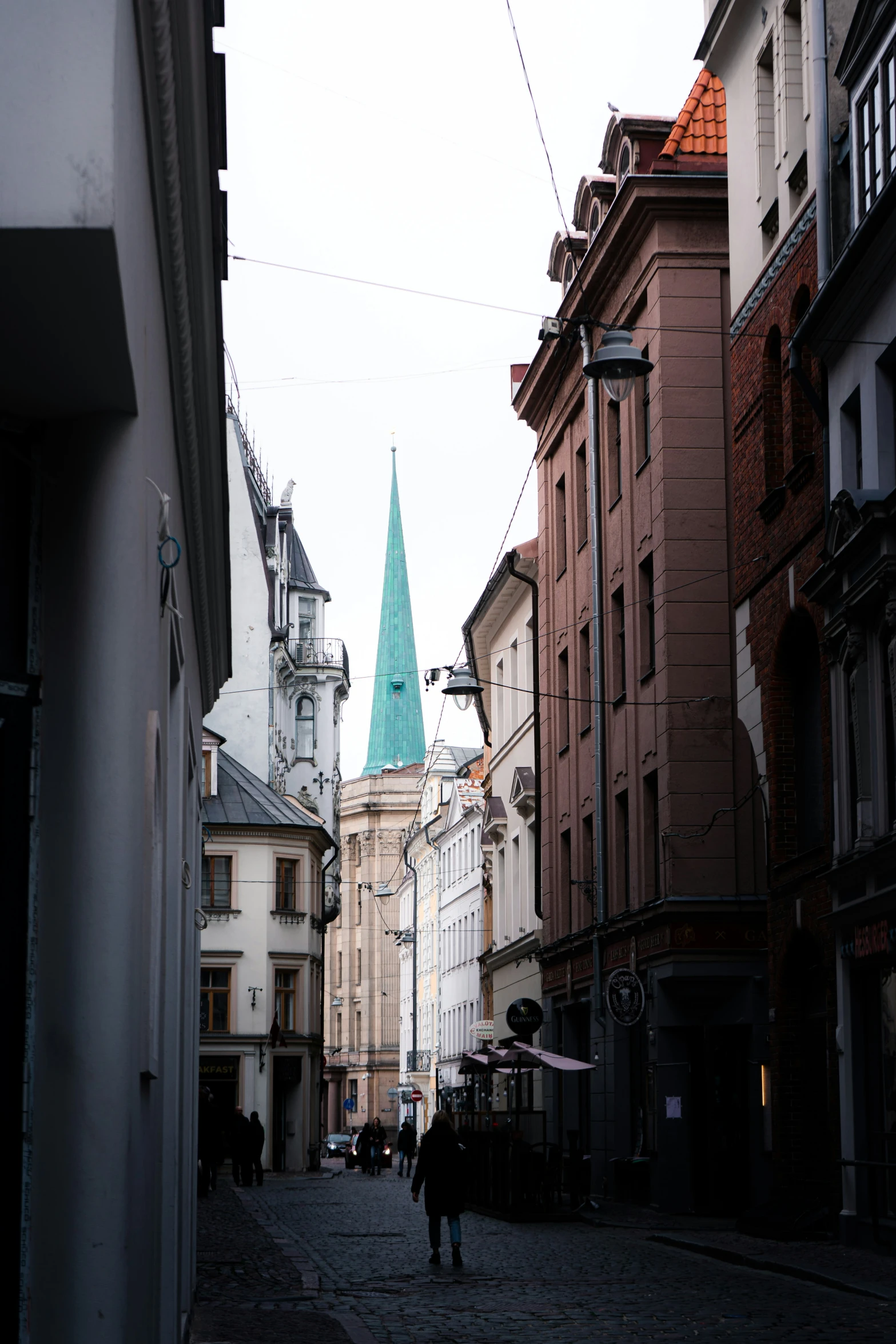 a man walking down a small cobblestone street