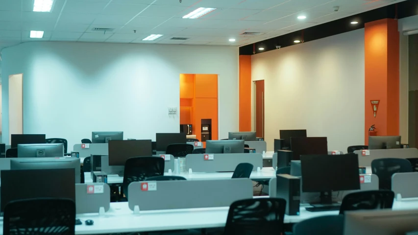 rows of desks sit in front of an empty office space