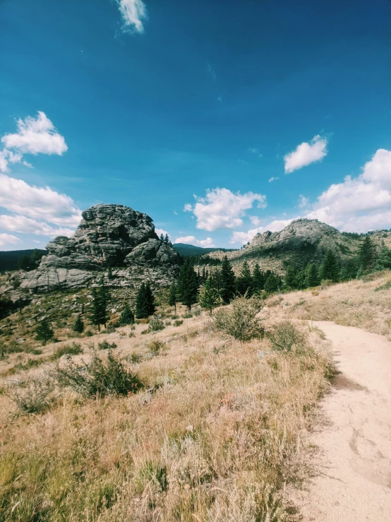 a grassy path that is surrounded by rocks