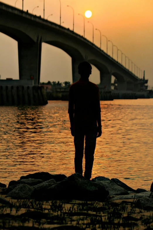 a person standing on some rocks near the water