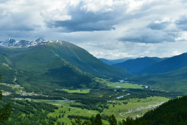 the valley in the mountains is surrounded by some green trees