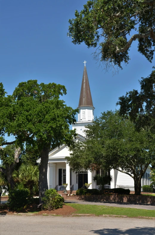 a small white church with a steeple in the middle of it