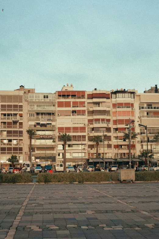 a parking lot with a building in the back and parked cars