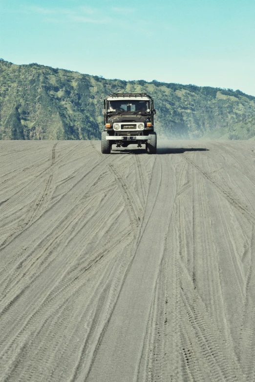 a truck driving in a vast vast open field