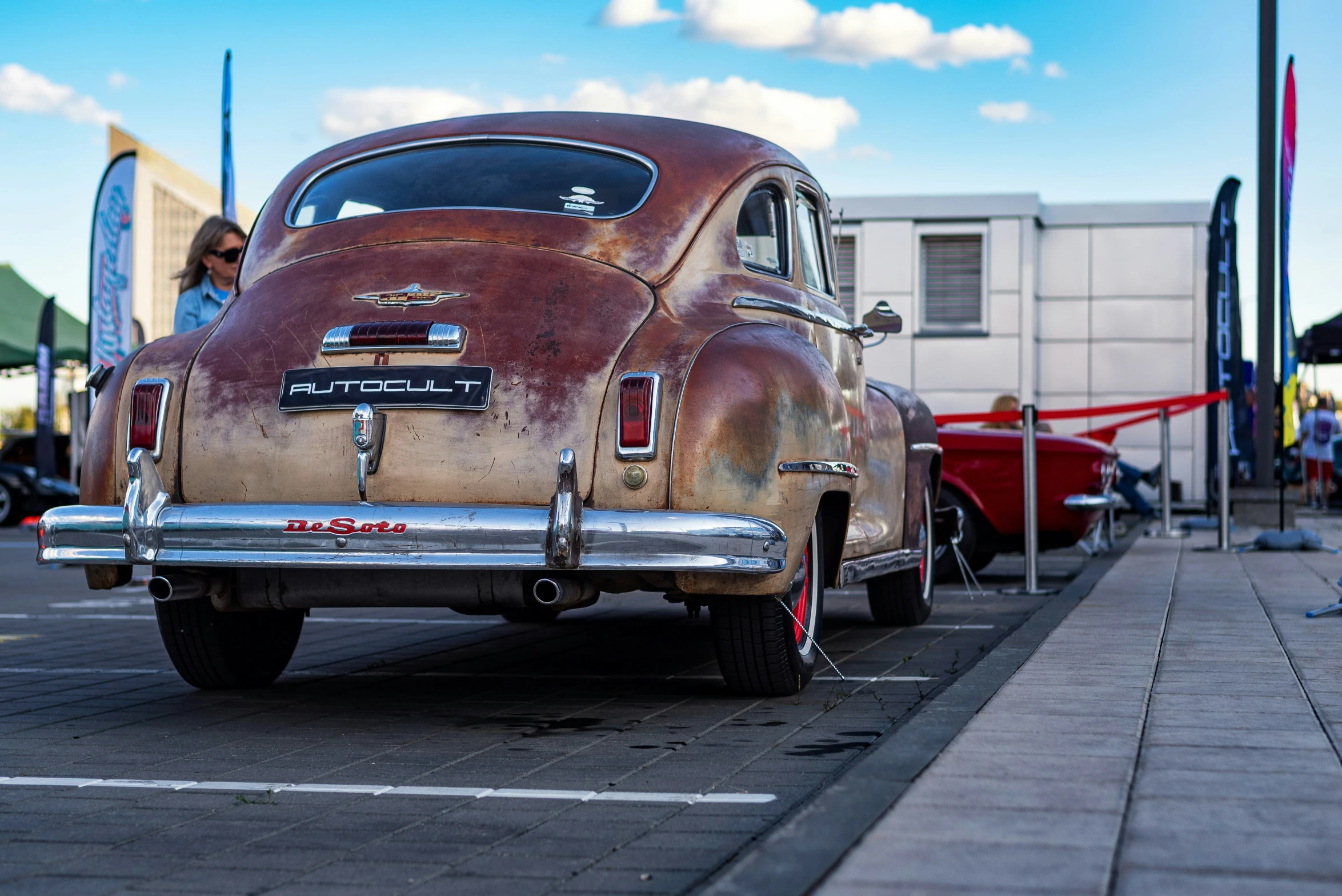 an old classic car parked next to a wall