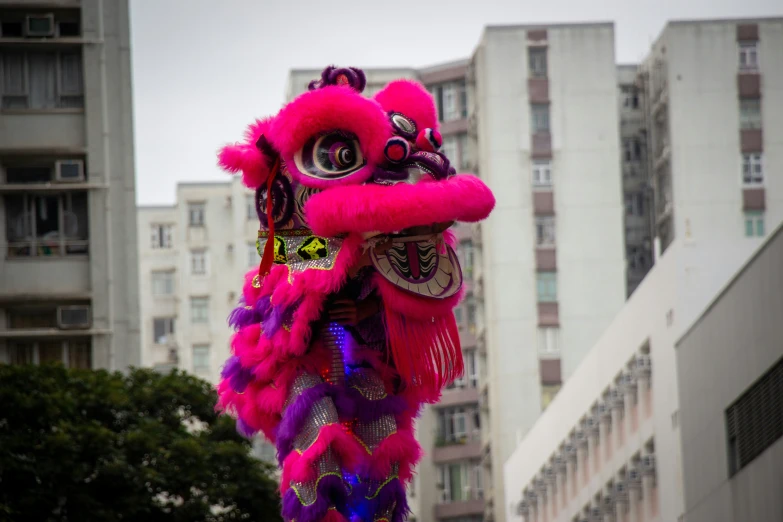 purple and red colored dragon head with building in background