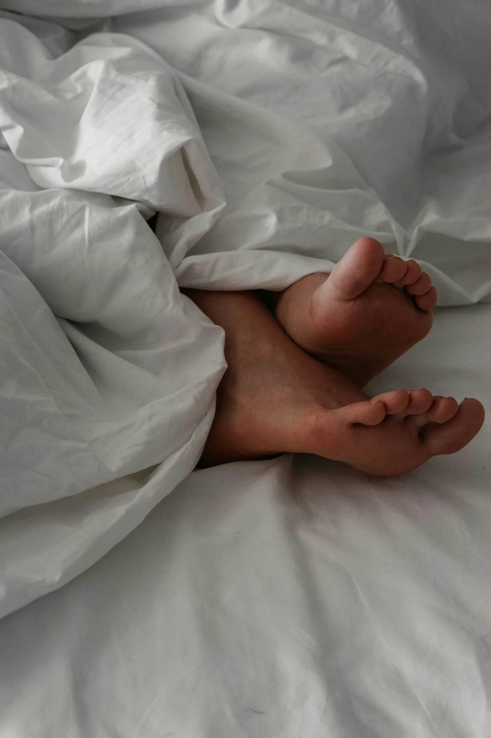 a person is under the covers of a bed