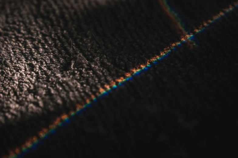 a black carpet with lines on it that are multicolored