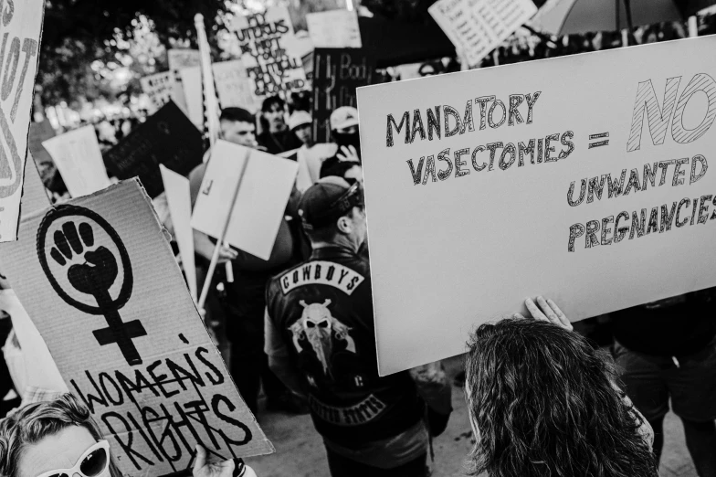 protesters march down a road in protest against vaccinated military groups