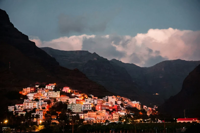 a town is on the side of a mountain at night