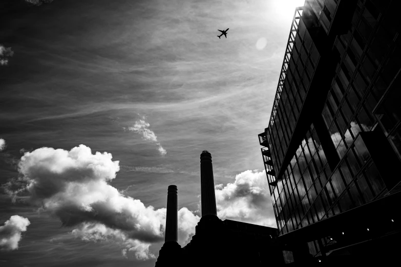 an airplane flying over the top of some tall buildings