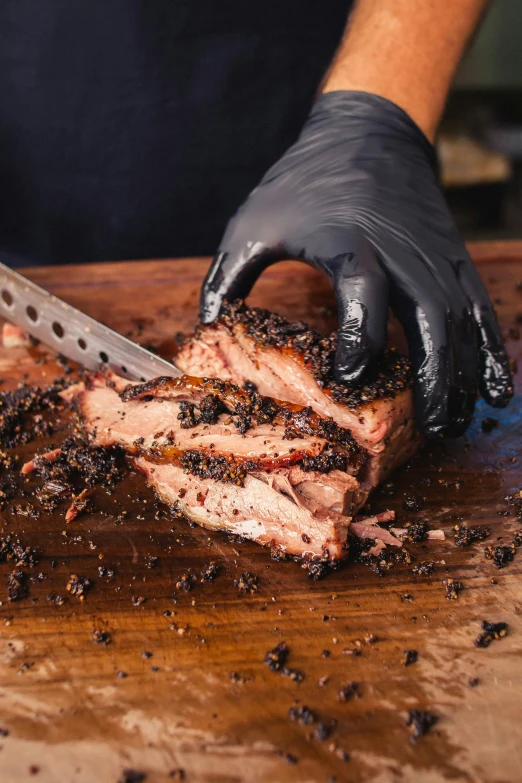 a chef holds a knife to cut up a cooked steak