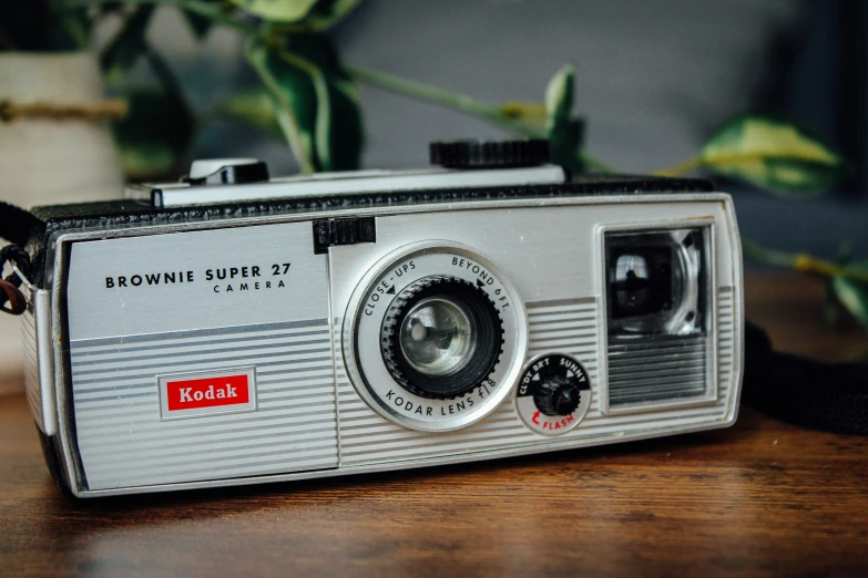 an old fashioned analog camera sitting on a wooden table