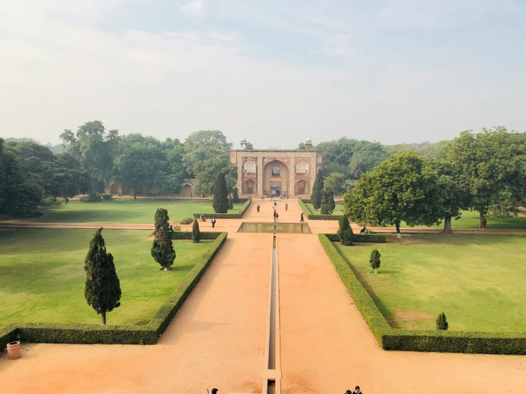 a beautiful park with trees and shrubs on both sides