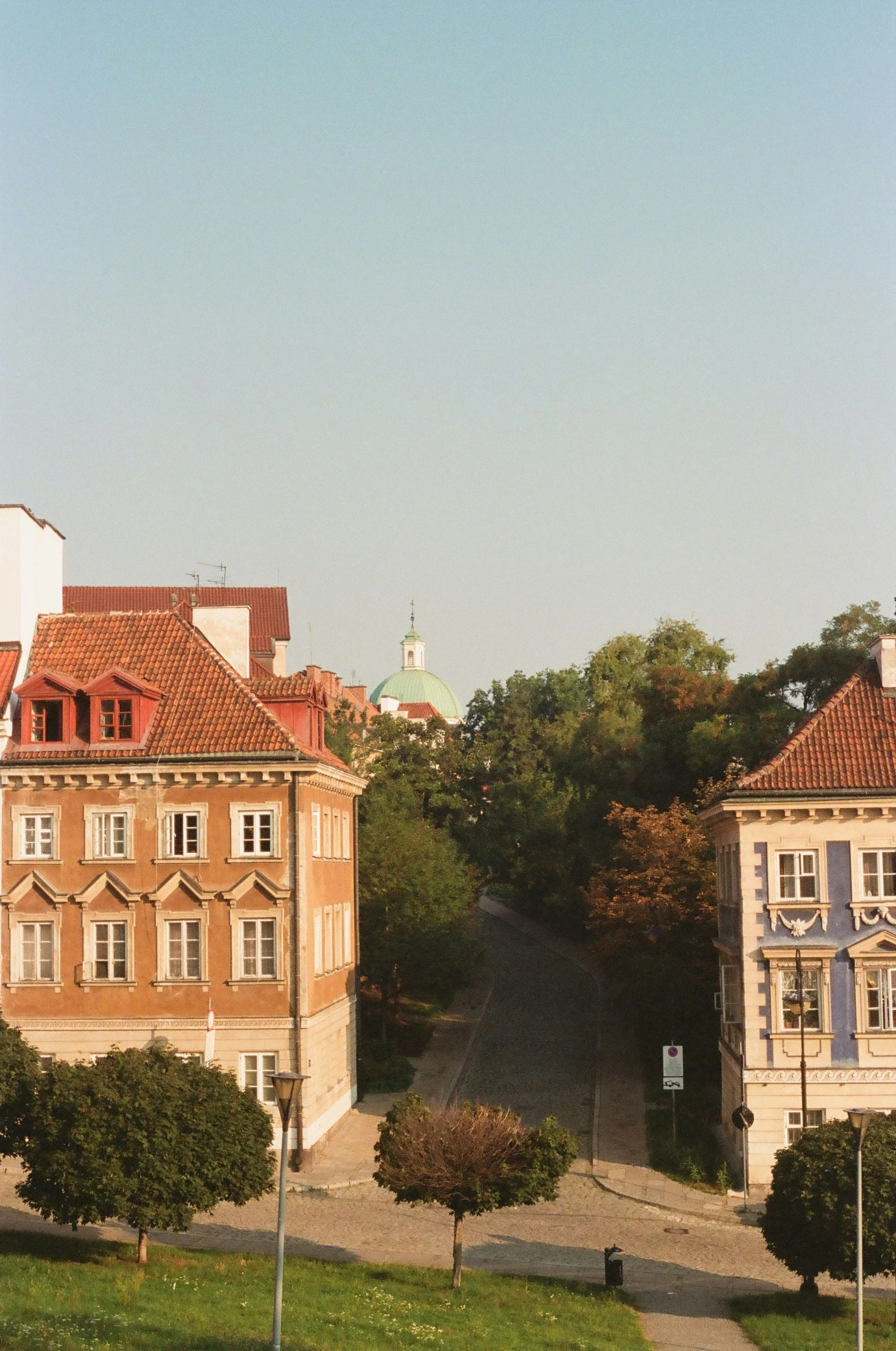 a street with tall buildings and many trees