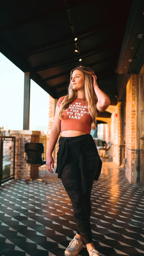 an attractive young woman poses outside on the sidewalk