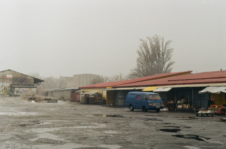 a couple of small buildings on the corner in the rain