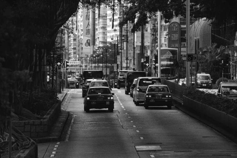 a black and white po of traffic on a street with tall buildings