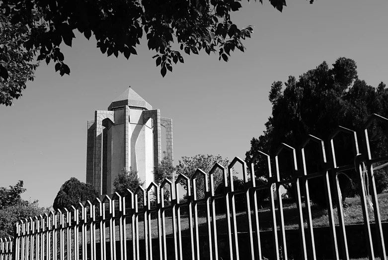 black and white pograph of a building behind a fence