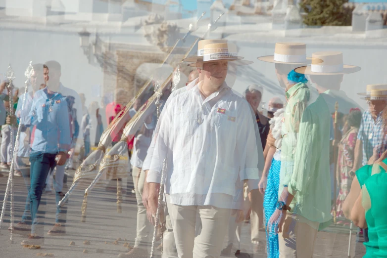 a man standing between two woman wearing hat's