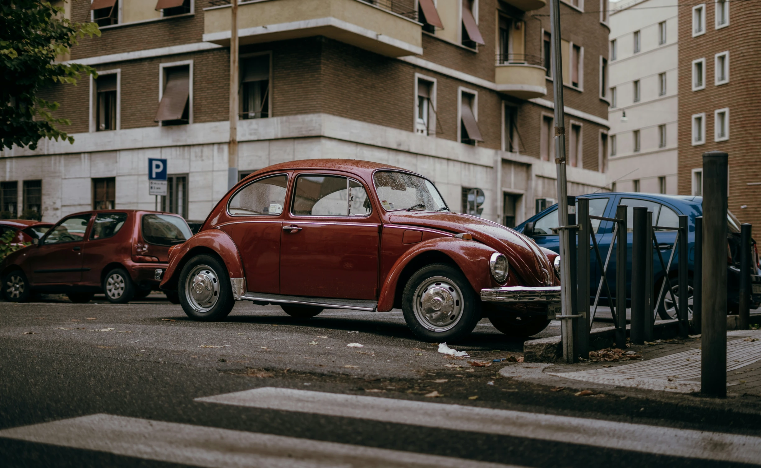 a red volkswagen car is parked next to another red car