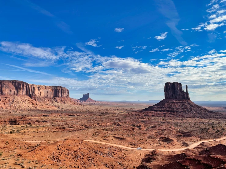 a dirt road and rock formations near the desert