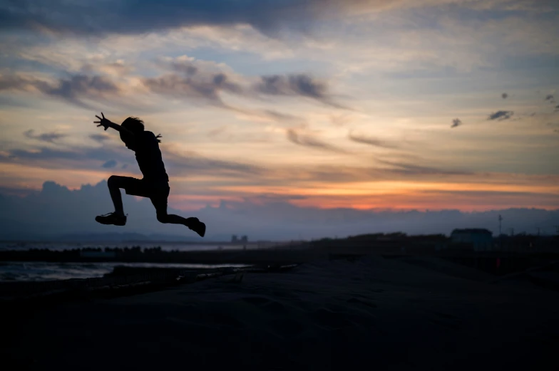 the silhouette of a person jumping into the air