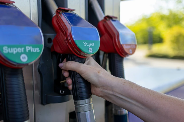 a hand is pumping gas into a gas station