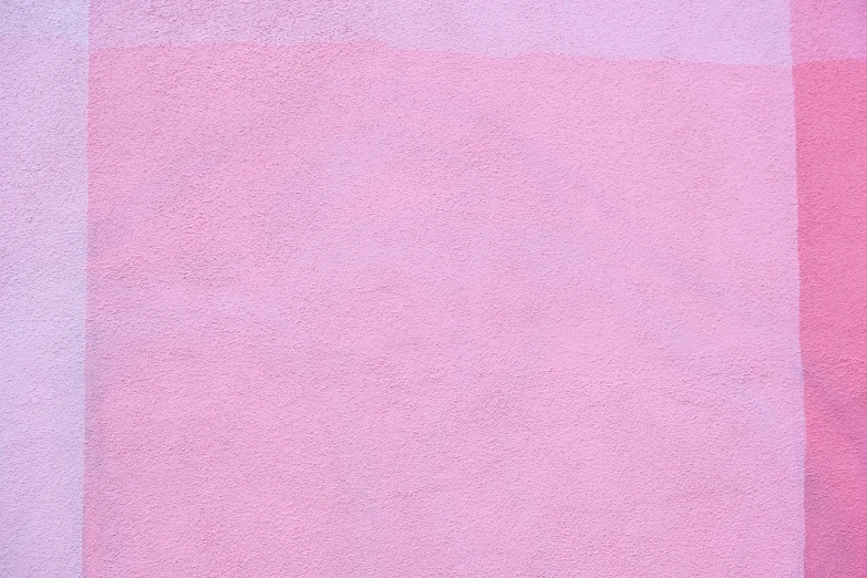 a bright pink wall with a small patch of dots