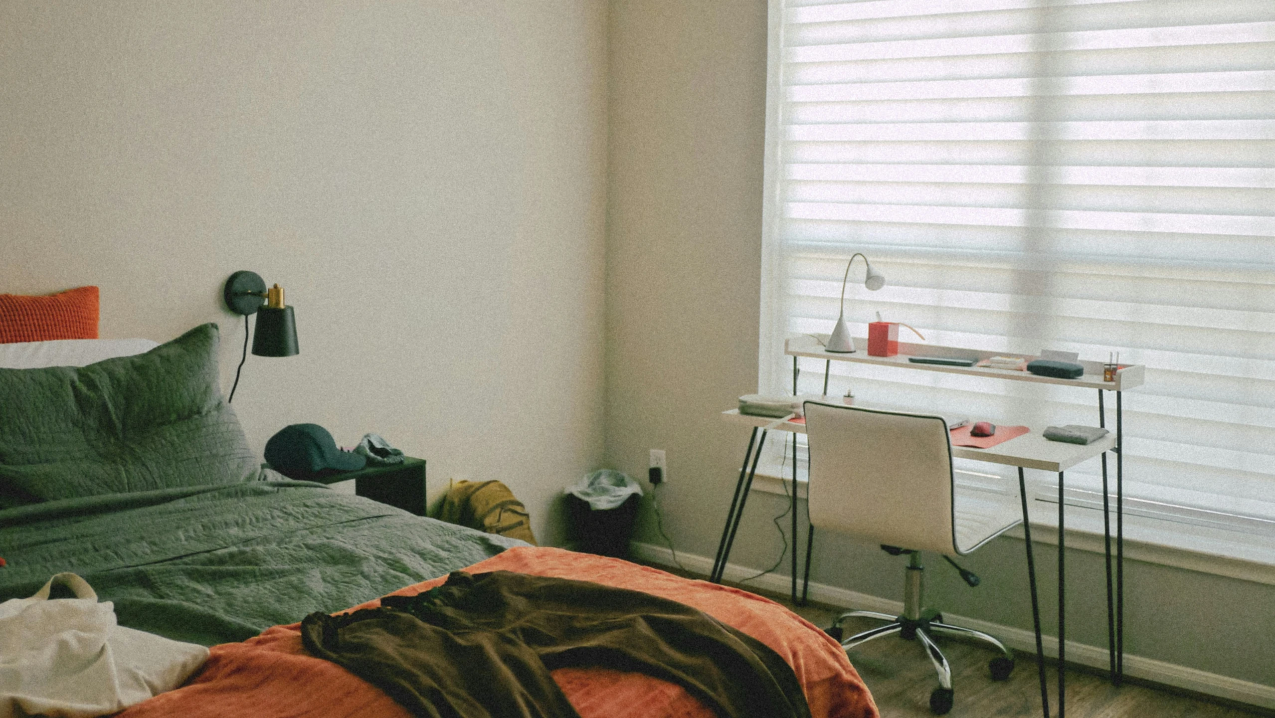 an empty bedroom with green linens and red sheets