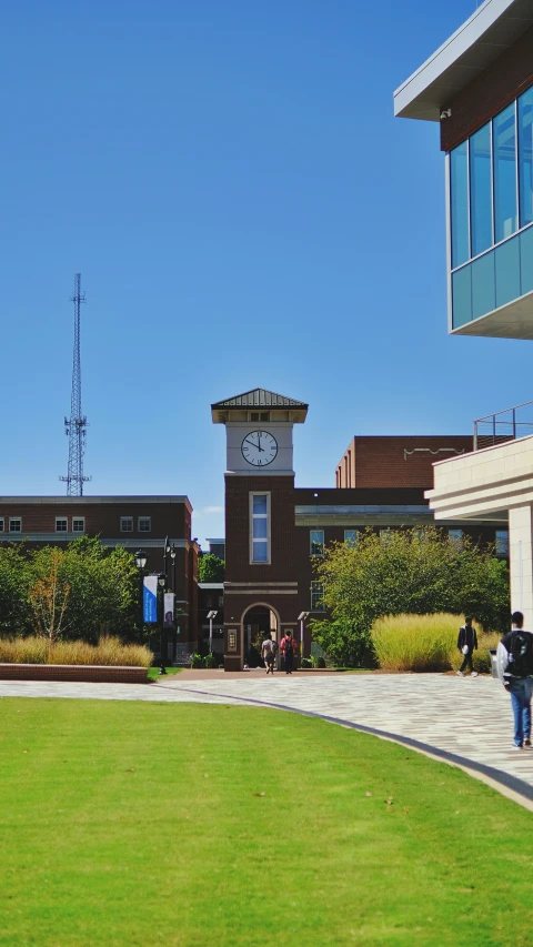 a clock tower in front of a building on a sunny day