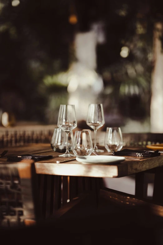 several wine glasses sit on an empty table