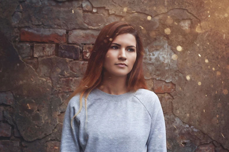 a young woman with frizzy red hair is posing for the camera