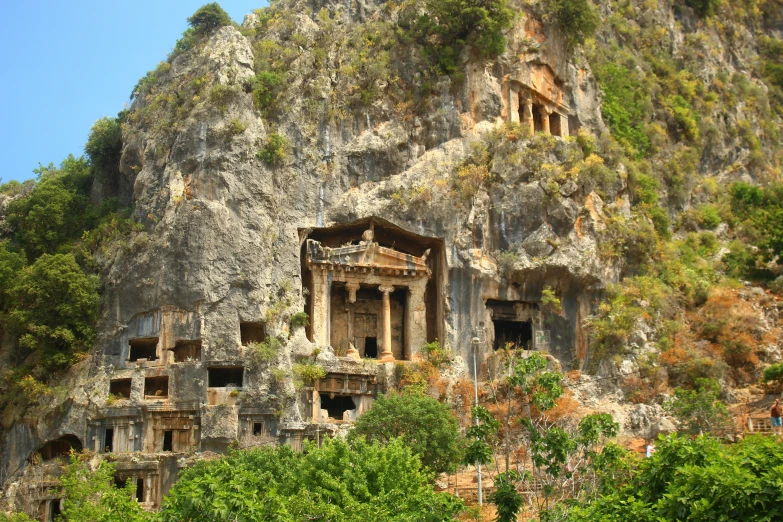 the ruins at the top of a cliff overlooks a waterfall