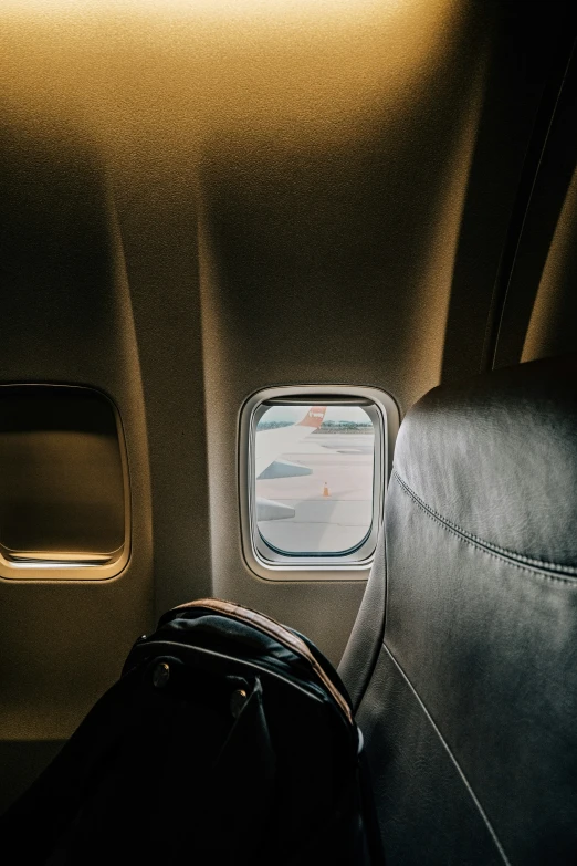 a window and seat with a luggage bag on the floor