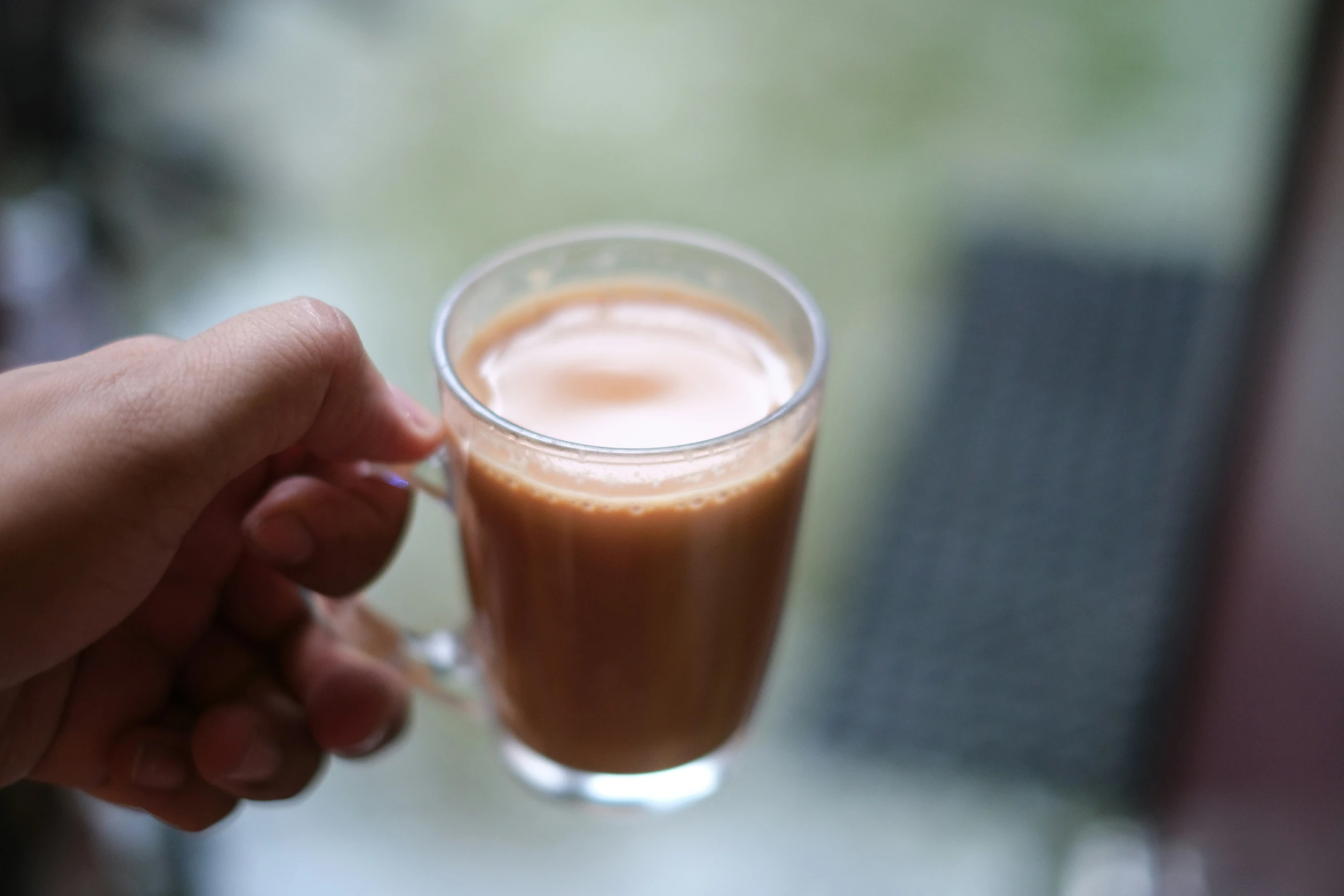 a person holding a drink in a glass