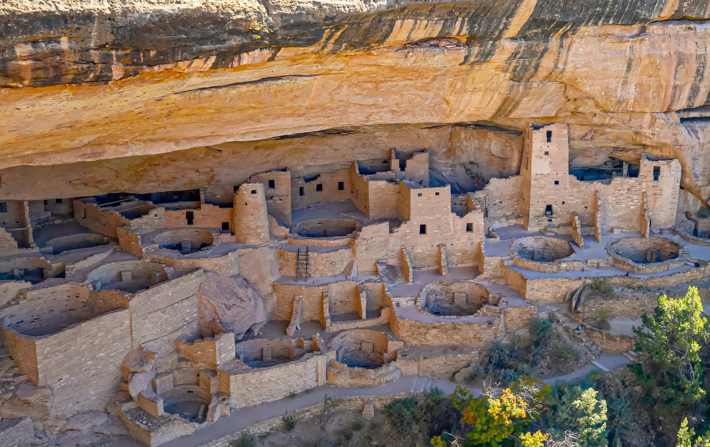 a beautiful cliff overlooking a valley and some stone structures