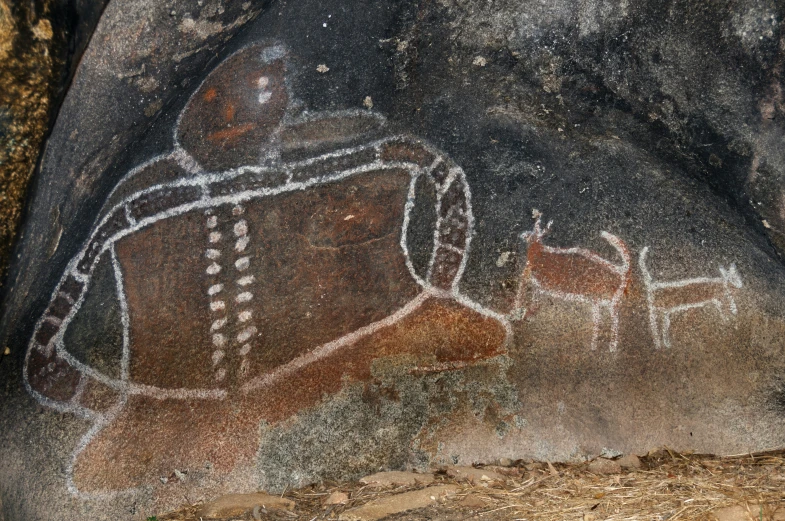 ancient rock paintings with a person holding an arm and a shield