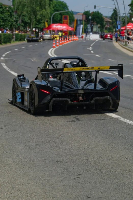 a racing car speeding down a road at the beginning of the race