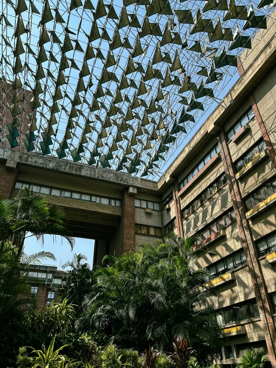 a building with a glass ceiling next to trees and bushes