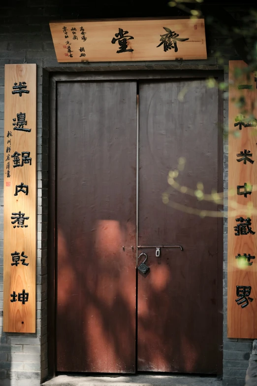 a double brown door with asian writing on it