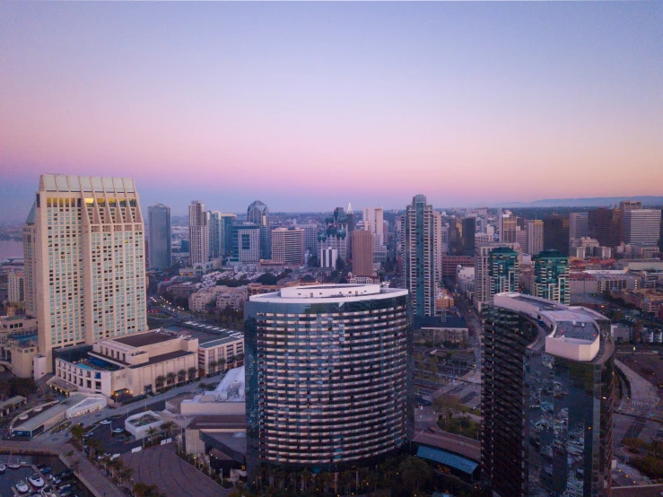 two tall buildings are in the distance and a red sunset