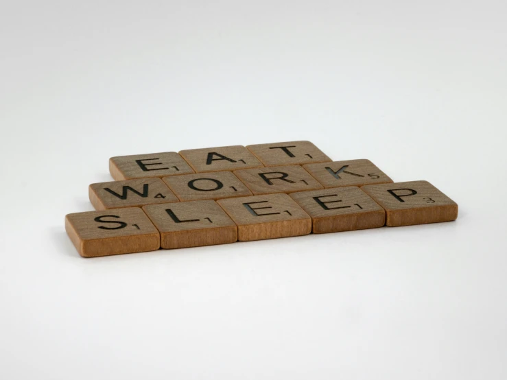 a scrabbled block with words on top reading death, work, sleep