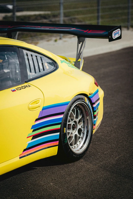 the yellow sports car with rainbow stripes painted on