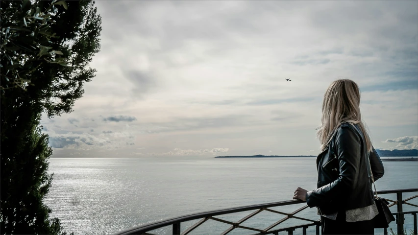 a woman looking over the side of the water from a balcony