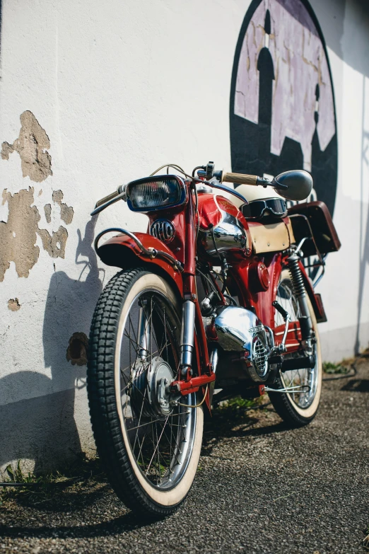 a red motorcycle is parked outside the wall