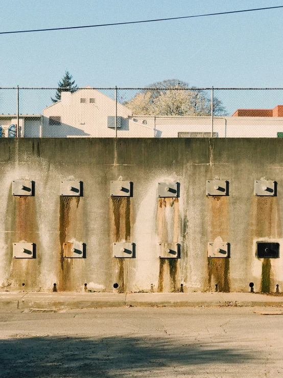 an abandoned concrete building and fence in front of the sky